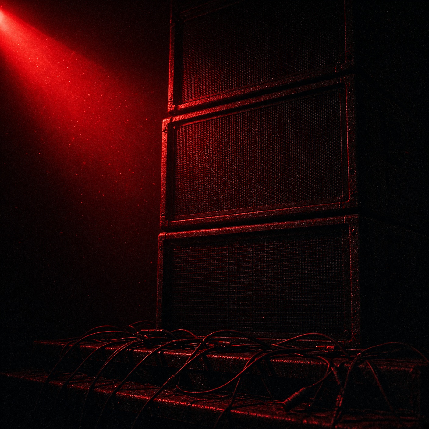 Speaker stack and cables under a red gel.