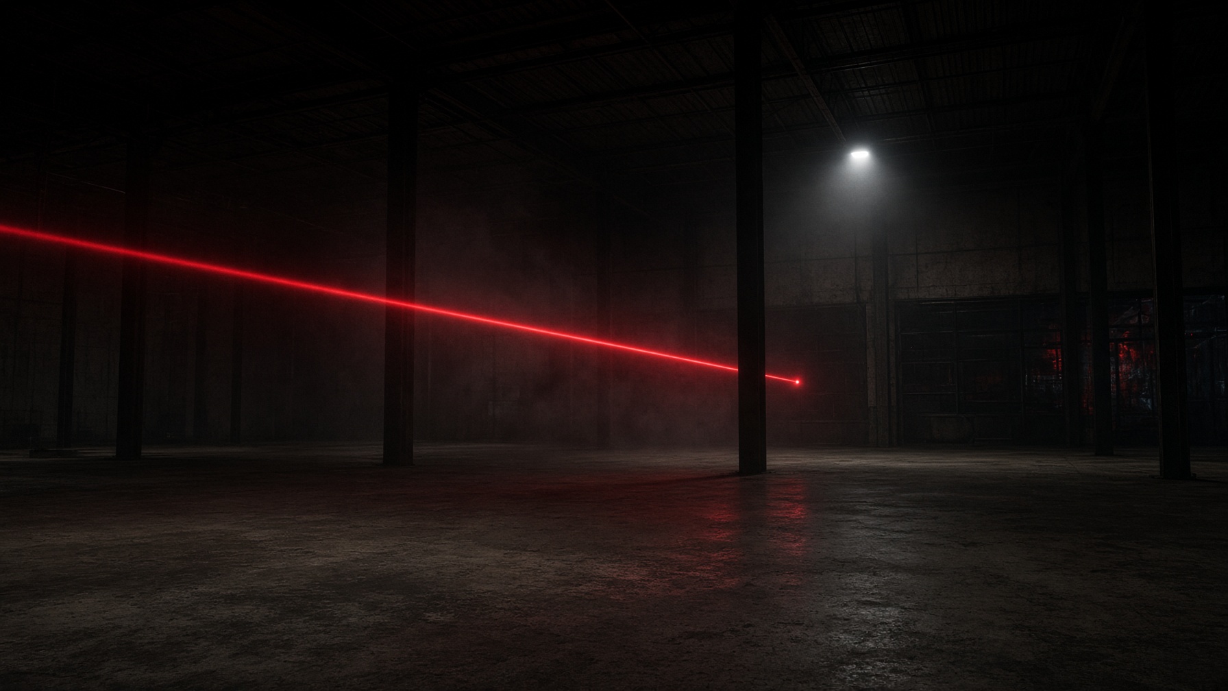 Empty warehouse at night, a red laser cutting through haze.